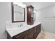 A bathroom with double sinks, white quartz countertops, dark wood cabinets, and decorative lights and mirrors at 202 Stoneleigh Dr, Cary, NC 27511