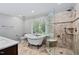 Spacious bathroom featuring a clawfoot tub, walk-in shower, and modern fixtures, illuminated by natural light at 202 Stoneleigh Dr, Cary, NC 27511