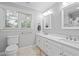 Bright bathroom featuring double sinks, marble countertops, modern fixtures, and natural light at 202 Stoneleigh Dr, Cary, NC 27511