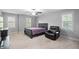 Carpeted bedroom featuring a ceiling fan, a bed and a comfortable leather recliner at 202 Stoneleigh Dr, Cary, NC 27511