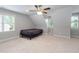 Bedroom featuring neutral walls, angled ceilings, carpet, and natural light from three windows at 202 Stoneleigh Dr, Cary, NC 27511