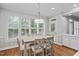 Sunlit dining area with hardwood floors and large windows overlooking the backyard at 202 Stoneleigh Dr, Cary, NC 27511