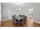 Formal dining room with stylish chandelier, hardwood floors, and access to kitchen at 202 Stoneleigh Dr, Cary, NC 27511