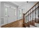 Bright foyer with hardwood floors, white trim, and elegant staircase with black iron spindles at 202 Stoneleigh Dr, Cary, NC 27511