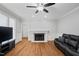 Cozy living room features a fireplace, hardwood floors, crown molding, and a leather sofa at 202 Stoneleigh Dr, Cary, NC 27511