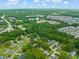 An aerial view presents a picturesque community with lush trees, a water tower, and a mix of housing options at 218 Forestville Rd, Wake Forest, NC 27587