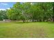 Spacious backyard with mature trees and a lush green lawn, ideal for outdoor activities at 218 Forestville Rd, Wake Forest, NC 27587