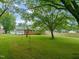Large, level backyard with lush green grass and mature trees offering plenty of shade and privacy at 218 Forestville Rd, Wake Forest, NC 27587
