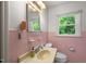 Bathroom with pink tile, window, single sink, and standard toilet at 218 Forestville Rd, Wake Forest, NC 27587