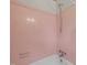 Bathtub and shower featuring original pink tile surround at 218 Forestville Rd, Wake Forest, NC 27587
