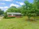 Inviting home featuring a lush green lawn, mature trees, and a classic brick facade at 218 Forestville Rd, Wake Forest, NC 27587