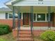 Charming front porch with brick steps and wrought iron railing, leading to the front door at 218 Forestville Rd, Wake Forest, NC 27587