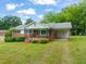 Charming brick home with a well-manicured front yard and covered porch at 218 Forestville Rd, Wake Forest, NC 27587