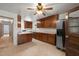 Full kitchen featuring ample wood cabinetry, spacious counters, stainless refrigerator and view to adjacent rooms at 218 Forestville Rd, Wake Forest, NC 27587