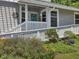 Inviting front entrance with a ramp, white railings, and vibrant flower beds leading to a blue front door at 224 Kirkwood Dr, Chapel Hill, NC 27514