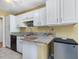 Bright kitchen features stone counters, white cabinetry, and stainless steel appliances at 224 Kirkwood Dr, Chapel Hill, NC 27514