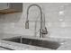 Close-up of a stainless steel kitchen faucet over a large sink with granite countertops at 2702 Red Valley Dr, Rougemont, NC 27572