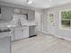 Well-lit kitchen featuring stainless steel appliances, gray cabinetry, and light-colored flooring at 2702 Red Valley Dr, Rougemont, NC 27572