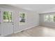 Inviting living room with a glass-paneled door, two windows, and light-colored flooring at 2702 Red Valley Dr, Rougemont, NC 27572