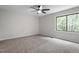 Comfortable bedroom with ceiling fan, neutral carpet, and a view of the trees at 2905 Scuppernong Ln, Durham, NC 27703