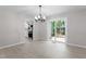 Open dining room with sliding glass doors, a chandelier, and kitchen access at 2905 Scuppernong Ln, Durham, NC 27703