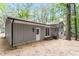 Back of house featuring gray siding, access to basement, and sliding door to patio at 2905 Scuppernong Ln, Durham, NC 27703