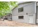 Side view of home with white painted brick foundation, gray siding and white doors at 2905 Scuppernong Ln, Durham, NC 27703