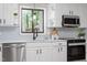 Contemporary kitchen featuring white cabinets, modern appliances, and stylish backsplash at 2905 Scuppernong Ln, Durham, NC 27703