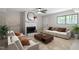 Comfortable living room featuring a fireplace, ceiling fan, and large windows at 2905 Scuppernong Ln, Durham, NC 27703