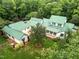 Expansive aerial view of the house showcasing a green metal roof, lush landscaping, and verdant surroundings at 300 Oak Ridge Dr, Hillsborough, NC 27278