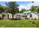 Spacious backyard featuring a lush lawn, mature trees, hot tub, and multiple outbuildings at 300 Oak Ridge Dr, Hillsborough, NC 27278
