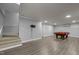 Open basement featuring hardwood floors, stairs, and a game room with a pool table at 300 Oak Ridge Dr, Hillsborough, NC 27278