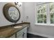 Bathroom featuring a decorative mirror over granite counters and a large window at 300 Oak Ridge Dr, Hillsborough, NC 27278