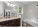 Bathroom featuring a wood vanity, large mirror, and shower-tub combination at 300 Oak Ridge Dr, Hillsborough, NC 27278