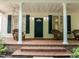 Inviting front porch with classic columns, shuttered windows, and wicker furniture, creating a welcoming entrance at 300 Oak Ridge Dr, Hillsborough, NC 27278