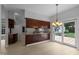 Open kitchen with wood cabinets, island cooktop, and sliding doors to the backyard at 300 Oak Ridge Dr, Hillsborough, NC 27278