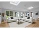 Bright and spacious living room with skylights, hardwood floors, and a large white sectional sofa at 300 Oak Ridge Dr, Hillsborough, NC 27278