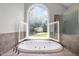 Main bathroom with large soaking tub, shower, and views of the private backyard at 300 Oak Ridge Dr, Hillsborough, NC 27278