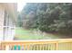 Backyard and partial view of house from deck, shows lawn, trees, and purple flowers at 3145 Pier Pointe Dr, Creedmoor, NC 27522