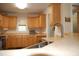 Well-lit kitchen featuring light wood cabinets, laminate countertops, and a double sink at 3145 Pier Pointe Dr, Creedmoor, NC 27522