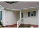 Covered porch with brick steps, a white railing and a storm door at 3145 Pier Pointe Dr, Creedmoor, NC 27522