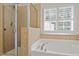 Bathroom features a separate glass-enclosed shower and soaking tub with window shutters for privacy at 3217 Ranbir Dr, Durham, NC 27713