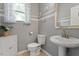 Charming powder room featuring decorative wall art, vessel sink, and a window with patterned curtains at 3217 Ranbir Dr, Durham, NC 27713