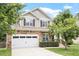 Charming two-story home features a stone facade, well-manicured lawn, and a two-car garage at 3217 Ranbir Dr, Durham, NC 27713
