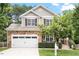 Charming two-story home features a stone facade, well-manicured lawn, and a two-car garage at 3217 Ranbir Dr, Durham, NC 27713
