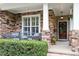 Inviting front porch with stone accents, comfortable seating, and a beautifully decorated entryway at 3217 Ranbir Dr, Durham, NC 27713
