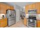 Well-lit kitchen featuring wooden cabinets, stainless steel appliances, and granite countertops at 3217 Ranbir Dr, Durham, NC 27713