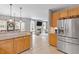 Modern kitchen featuring granite counters, stainless refrigerator and view to living area at 3217 Ranbir Dr, Durham, NC 27713