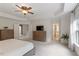 Bright main bedroom featuring a ceiling fan, neutral decor, and an adjoining bathroom and walk-in closet at 3217 Ranbir Dr, Durham, NC 27713