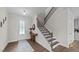 Bright foyer with hardwood floors, staircase, and decorative table with floral arrangement at 3421 Lebrun Path, Fuquay Varina, NC 27526